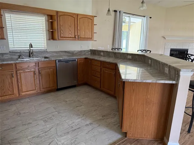 a kitchen with granite countertop a sink stove and cabinets