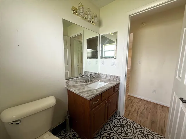 a bathroom with a granite countertop sink and a mirror