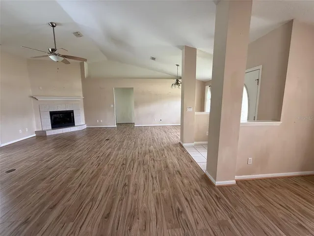 a view of empty room with wooden floor and fireplace