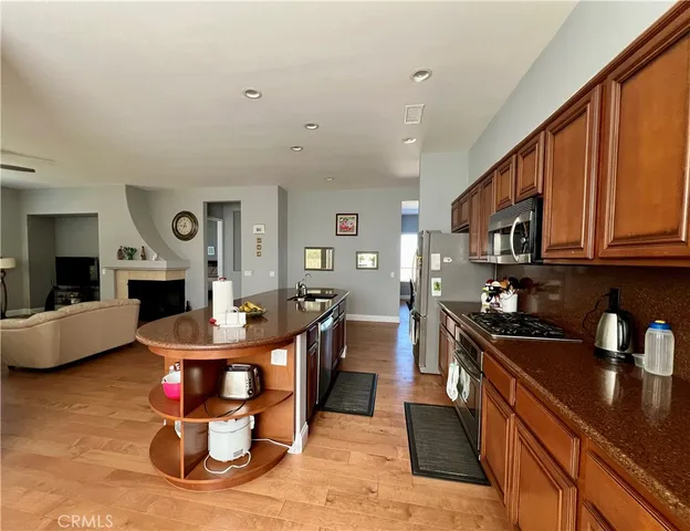 a kitchen with stainless steel appliances granite countertop a stove refrigerator and cabinets