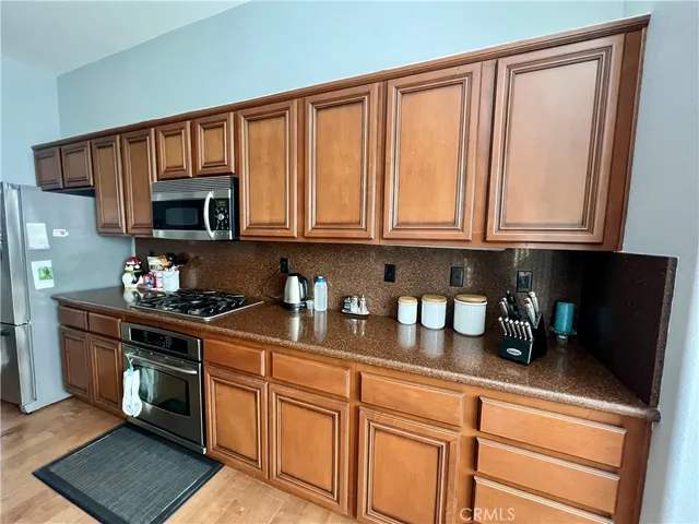 a kitchen with stainless steel appliances granite countertop a stove a sink and a microwave