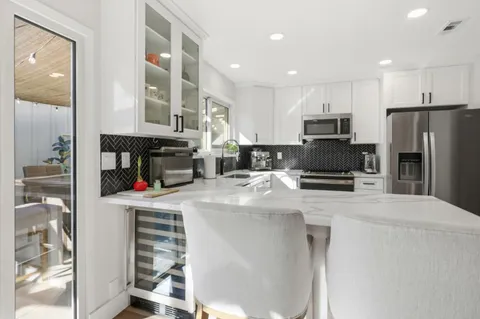 a kitchen with granite countertop a refrigerator stove and sink