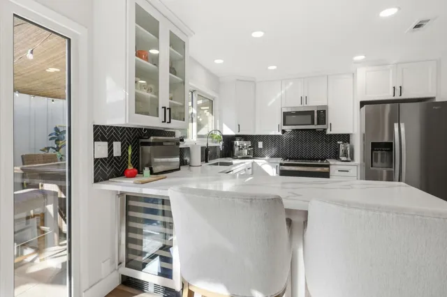 a kitchen with granite countertop a refrigerator stove and sink