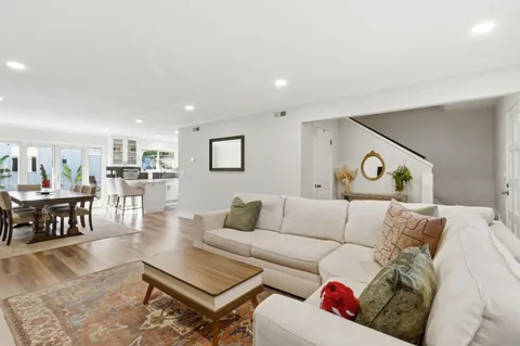 a living room with furniture a rug and a wall painting