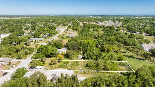 an aerial view of residential houses with outdoor space and trees