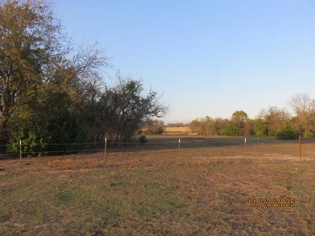 a view of outdoor space with green field and trees