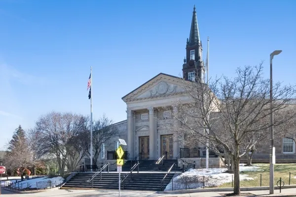 a front view of a building with trees