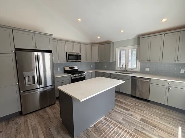 a kitchen with stainless steel appliances a refrigerator sink and microwave