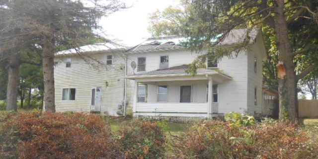 17294 Sumner Road Pecatonica, IL 61063 - Photo 2 of 10 a view of a white house with large windows and a tree