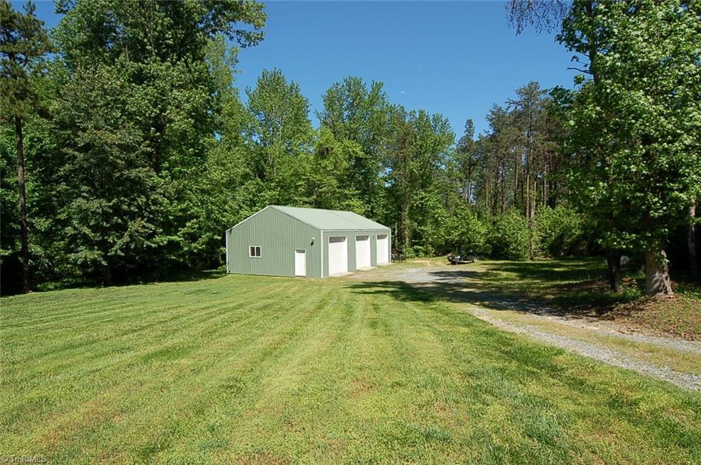6205 Monnett Road Julian, NC 27283 - Photo 28 of 30 The garage shop building has three bays. It is wired and pre-plumbed for a bath. Separate HVAC. Also: beautiful trees and so much lawn!