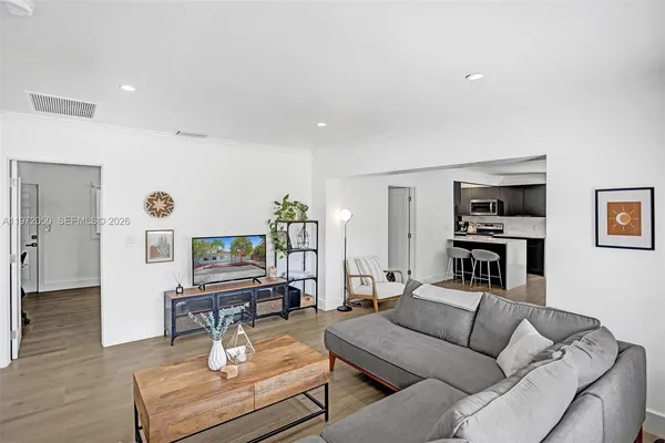 a living room with furniture and a wooden floor
