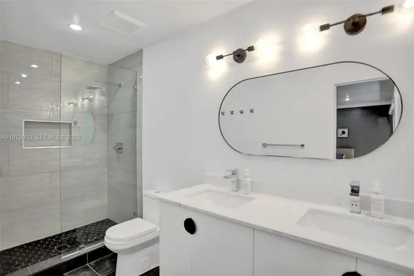 a bathroom with a sink a toilet and shower