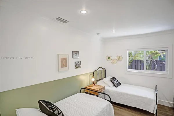 a bedroom with a bed and wooden floor