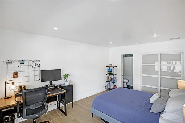 a bedroom with a bed and a computer on a desk