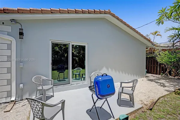 a backyard of a house with table and chairs