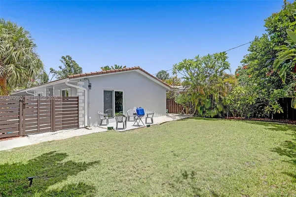 a view of a house with backyard and sitting area