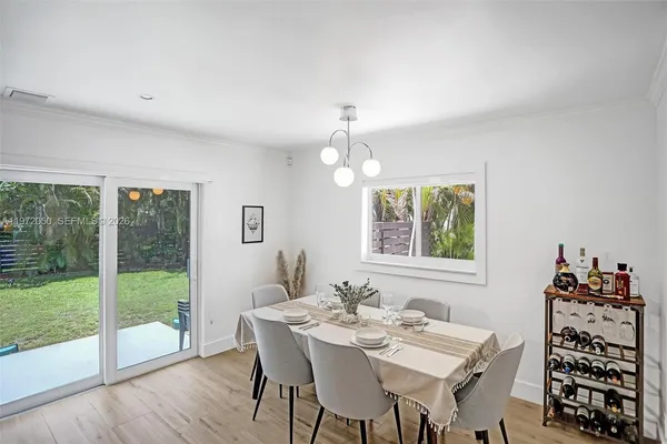 a view of a dining room with furniture large windows and wooden floor