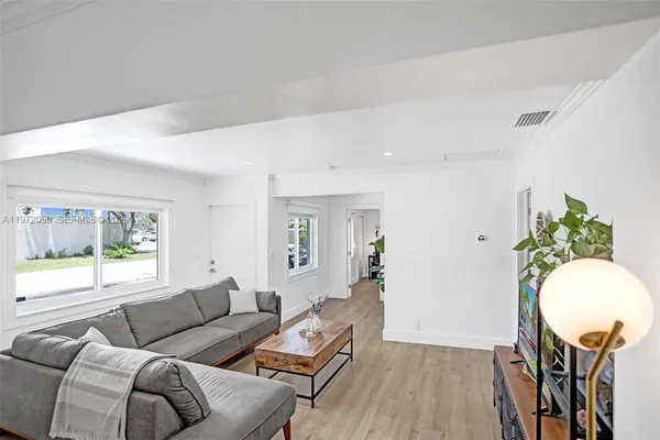 a living room with furniture and a wooden floor