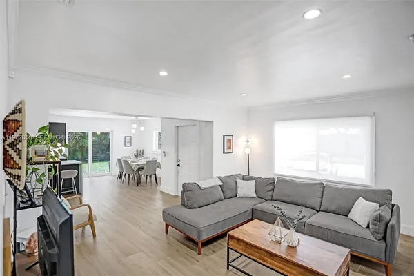 a living room with furniture a dining table and a large window