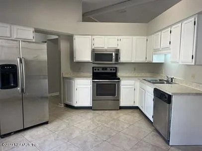 a kitchen with white cabinets and stainless steel appliances