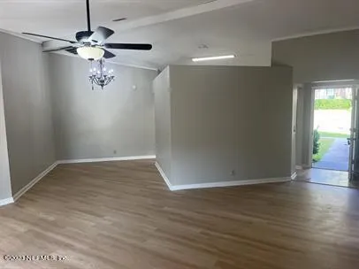 a view of an empty room with wooden floor