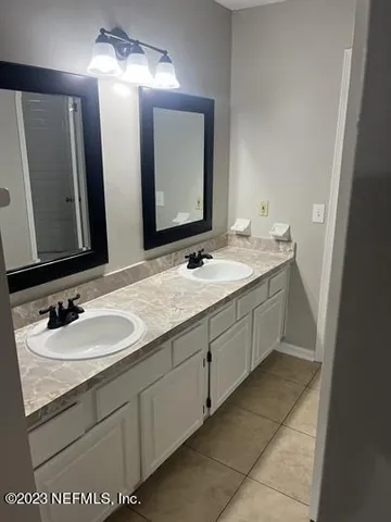a bathroom with a double vanity sink and a mirror