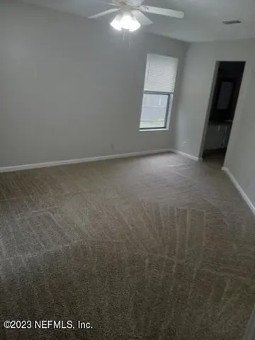 an empty room with windows and mirror