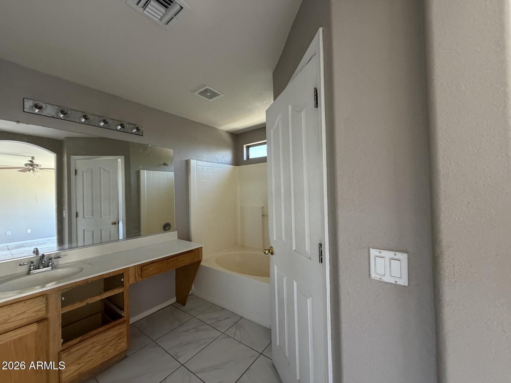 10807 West Monte Vista Road Avondale, AZ 85392 - Photo 31 of 33 a spacious bathroom with a double vanity sink and a mirror