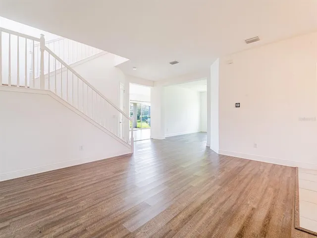 a view of an empty room with wooden floor