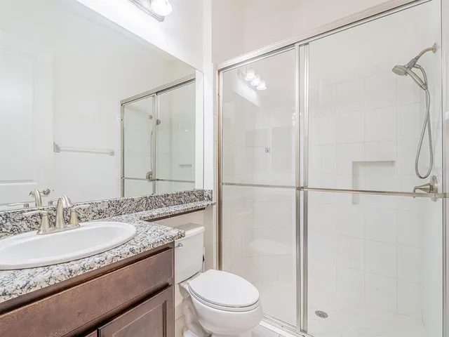 a bathroom with a granite countertop toilet a sink and a bathtub