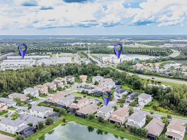an aerial view of residential houses with outdoor space and trees all around
