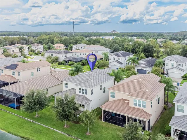 an aerial view of a house with a garden and lake view