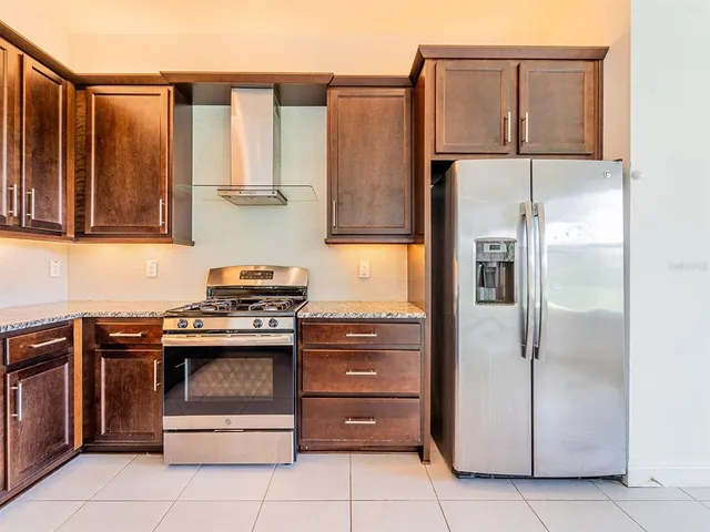 a kitchen with stainless steel appliances granite countertop a refrigerator and a stove