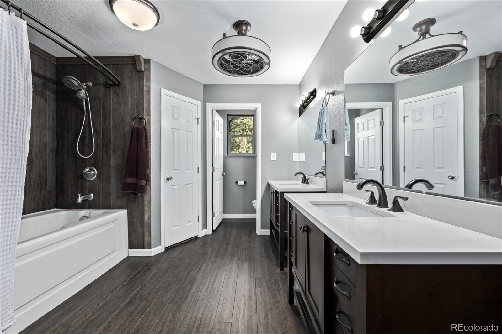 20 Parkview Bailey, CO 80421 - Photo 29 of 50 a bathroom with a double vanity sink a mirror a bathtub and shower