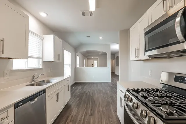 a kitchen with stainless steel appliances granite countertop a stove and a sink