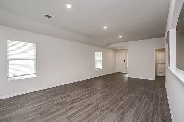 an empty room with wooden floor and window