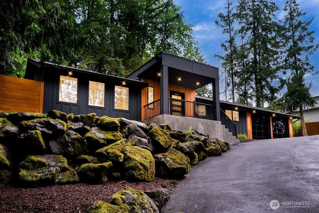 a front view of a house with a large tree