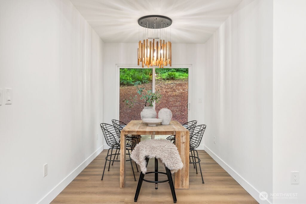 19433 Southeast 128th Street Renton, WA 98059 - Photo 23 of 40 a view of a dining room with furniture a chandelier and wooden floor