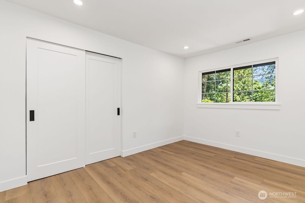19433 Southeast 128th Street Renton, WA 98059 - Photo 28 of 40 a view of an empty room with wooden floor and a window