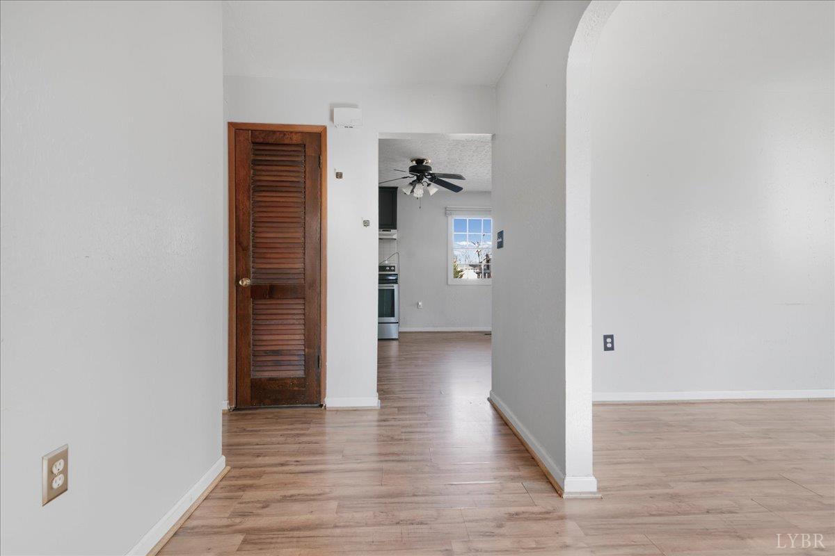 a view of a hallway with wooden floor and closet