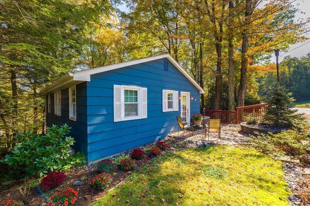 117 May Brook Road Holland, MA 01521 - Photo 3 of 30 a view of a backyard with table and chairs potted plants and large tree