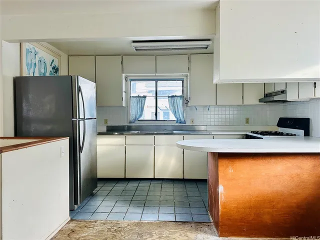 a kitchen with stainless steel appliances granite countertop a refrigerator and a window