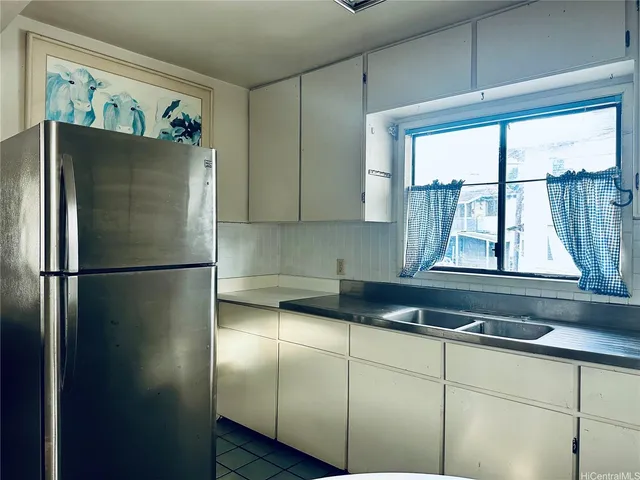 a kitchen with stainless steel appliances granite countertop a sink and a white cabinets