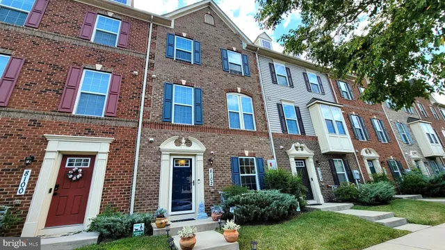 a front view of a multi story residential apartment building with yard and green space