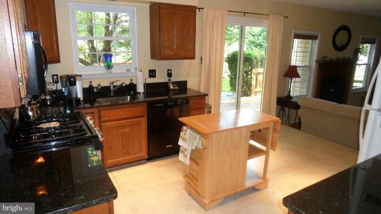 a kitchen with stainless steel appliances a stove a refrigerator a sink and wooden cabinets