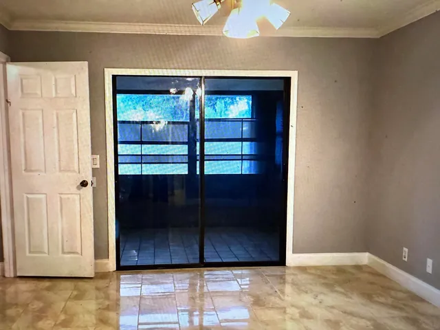 a view of a refrigerator in kitchen and an empty room
