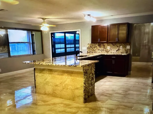 a view of kitchen sink and wooden cabinets