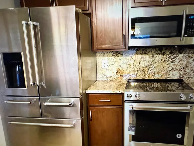 a kitchen with granite countertop a stainless steel appliances and cabinets