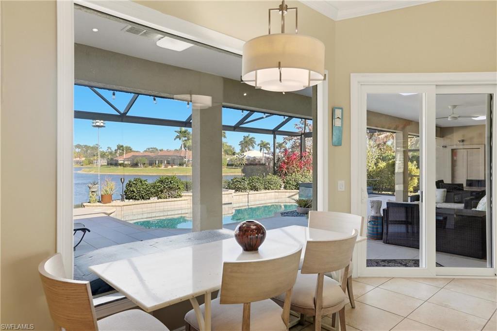 11180 Phoenix Way Naples, FL 34119 - Photo 12 of 43 Dining area featuring a sunroom, light tile patterned floors, and a water view