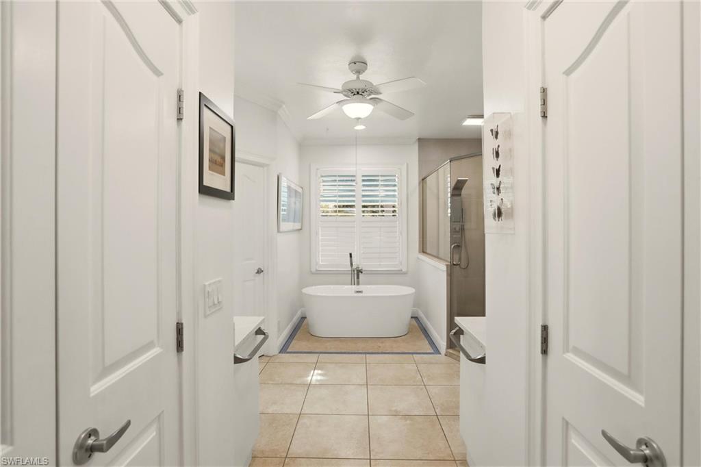 11180 Phoenix Way Naples, FL 34119 - Photo 16 of 43 Bathroom with a shower stall, light tile patterned floors, a freestanding bath, ceiling fan, and ornamental molding